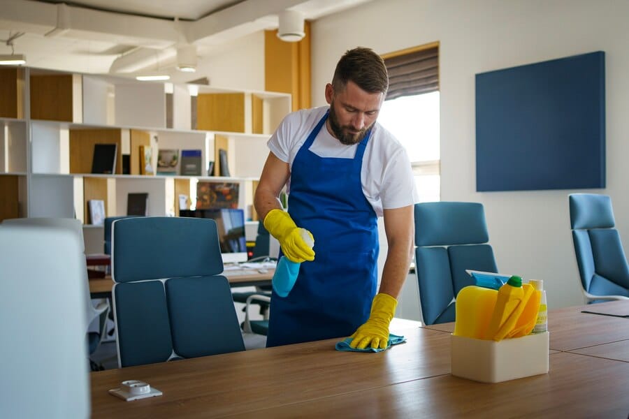 A man cleaning a office table
