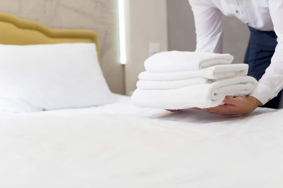 hotel staff cleaning bed